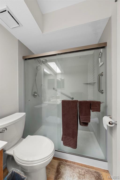 12944 Bryce Canyon Dr, Maryland Heights, MO 63043 - full bathroom with vanity, toilet, a stall shower, and wood finished floors
