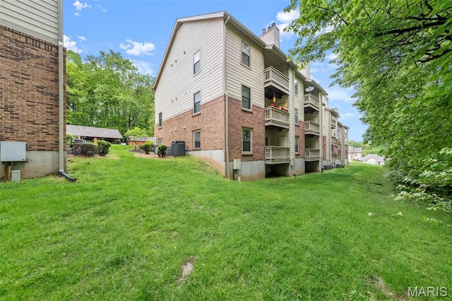 12944 Bryce Canyon Dr, Maryland Heights, MO 63043 - back of property with a chimney, a lawn, brick siding, and central AC unit