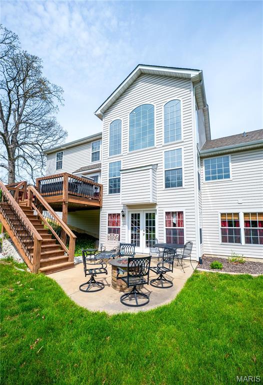 1004 Kodiak Ct, Wentzville, MO 63385 - back of property featuring stairs, french doors, a lawn, a patio, and a deck