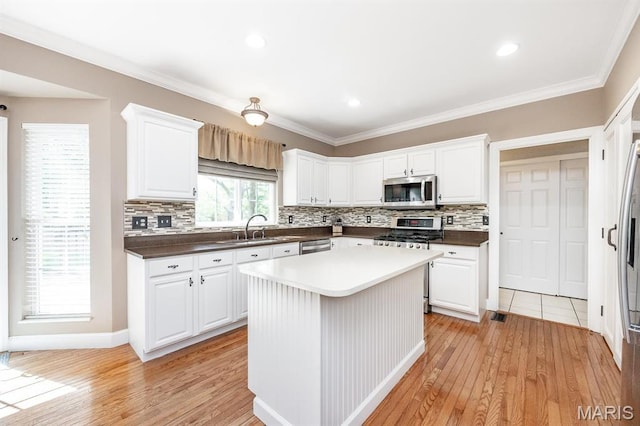 1237 Conrad Ln, Ofallon, IL 62269 - kitchen featuring stainless steel appliances, light wood-style flooring, a sink, backsplash, and ornamental molding