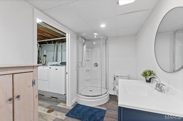 full bath featuring separate washer and dryer, wood finished floors, a stall shower, and vanity