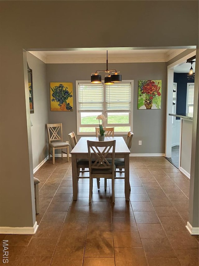 303 Greenbriar, Rolla, MO 65401 - dining room with crown molding, a chandelier, baseboards, and dark tile patterned floors