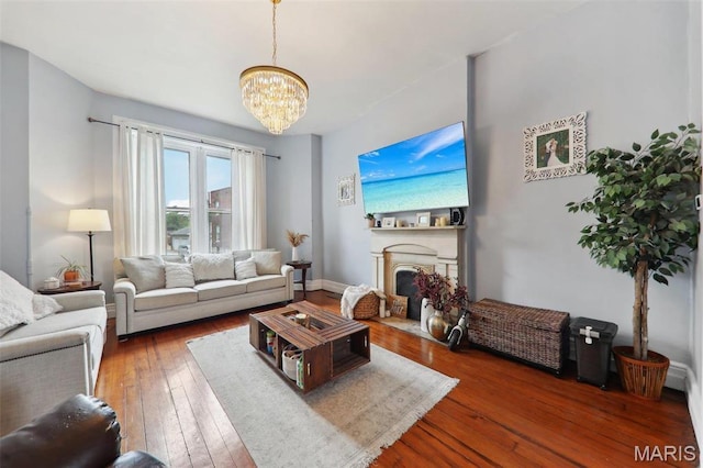 2116 Victor St, Saint Louis, MO 63104 - living room featuring a chandelier, wood-type flooring, a fireplace with flush hearth, and baseboards