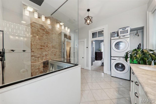 2116 Victor St, Saint Louis, MO 63104 - bathroom featuring stacked washer and clothes dryer, tile patterned flooring, vanity, walk in shower, and baseboards