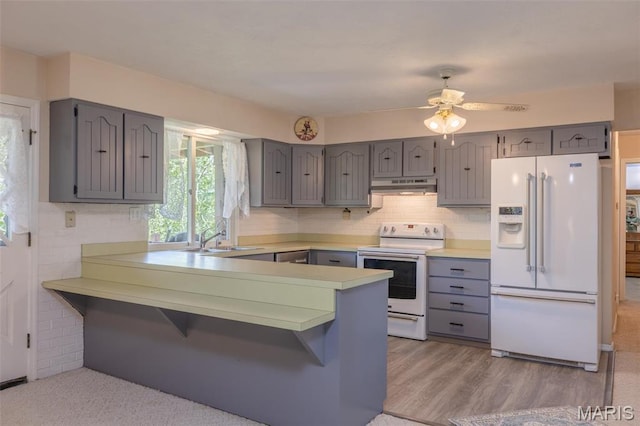 6344 Gibison Rd, Troy, MO 63379 - kitchen featuring white appliances, gray cabinets, a sink, a peninsula, and under cabinet range hood