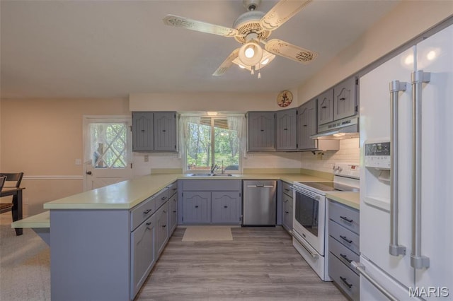 6344 Gibison Rd, Troy, MO 63379 - kitchen with white appliances, a peninsula, a sink, gray cabinets, and light countertops