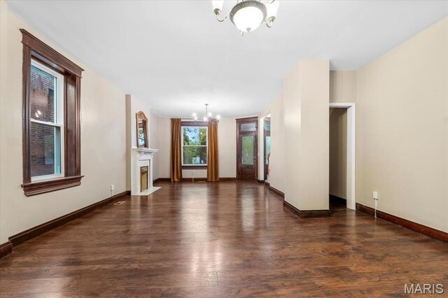 5518 Alaska Ave, Saint Louis, MO 63111 - unfurnished living room featuring a chandelier, wood finished floors, baseboards, and a fireplace with flush hearth