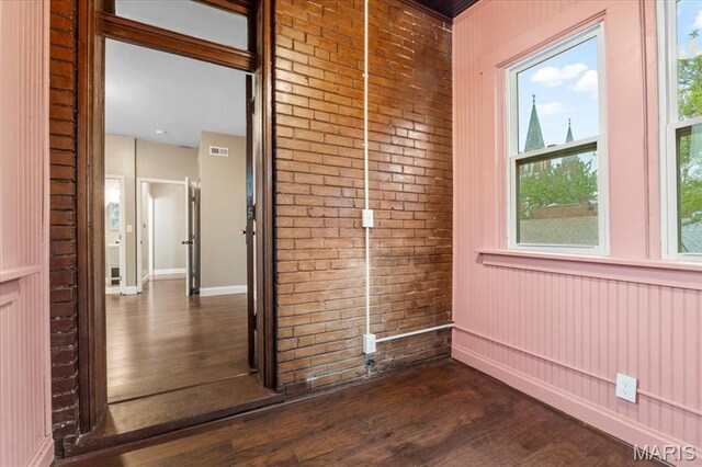 5518 Alaska Ave, Saint Louis, MO 63111 - interior space with dark wood-style floors, baseboards, and brick wall