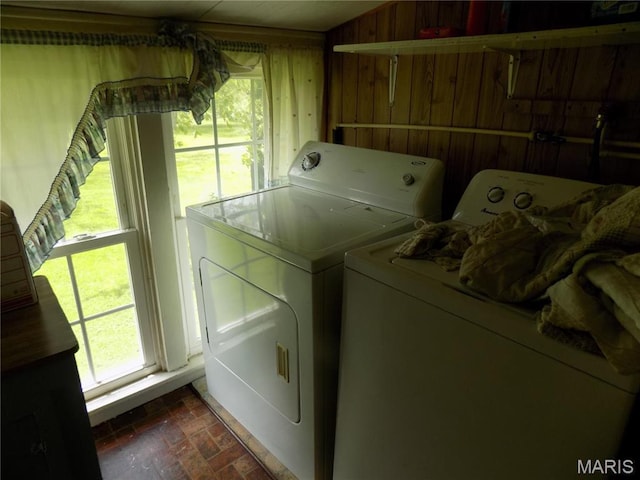 525 Russellville Rd, Arcadia, MO 63621 - laundry room featuring washing machine and clothes dryer, brick patterned flooring, wood walls, and plenty of natural light