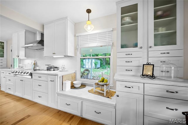 3066 W Meyer Rd, Foristell, MO 63348 - kitchen featuring wall chimney exhaust hood, backsplash, white cabinetry, light wood finished floors, and glass insert cabinets