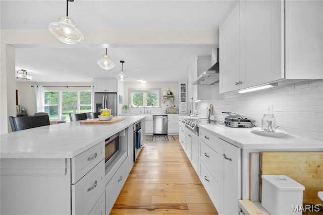 3066 W Meyer Rd, Foristell, MO 63348 - kitchen featuring stainless steel appliances, wall chimney exhaust hood, white cabinets, tasteful backsplash, and a large island