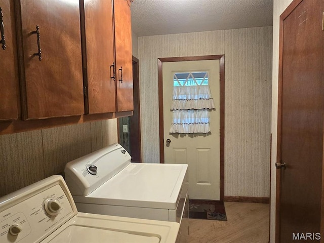 16043 County Road 624, Dexter, MO 63841 - clothes washing area featuring washing machine and clothes dryer, cabinet space, wallpapered walls, a textured ceiling, and baseboards