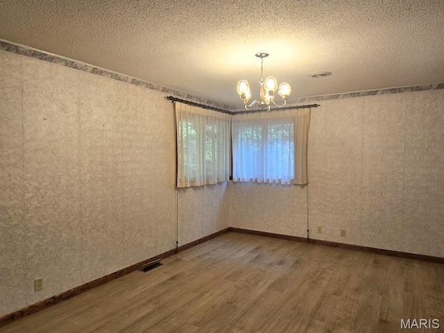 16043 County Road 624, Dexter, MO 63841 - unfurnished room with wood finished floors, a chandelier, and a textured ceiling