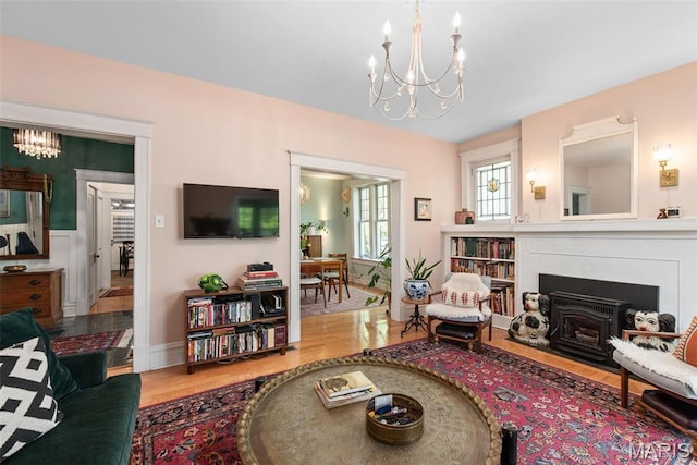 2056 Lafayette Ave Unit 1W, Saint Louis, MO 63104 - living area with a chandelier, wood finished floors, baseboards, and a fireplace with flush hearth