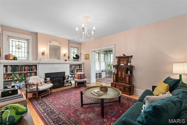 2056 Lafayette Ave Unit 1W, Saint Louis, MO 63104 - living area featuring a chandelier, wood finished floors, a fireplace with flush hearth, and baseboards