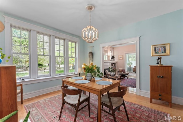 2056 Lafayette Ave Unit 1W, Saint Louis, MO 63104 - dining room with a chandelier, light wood-style floors, baseboards, and a fireplace