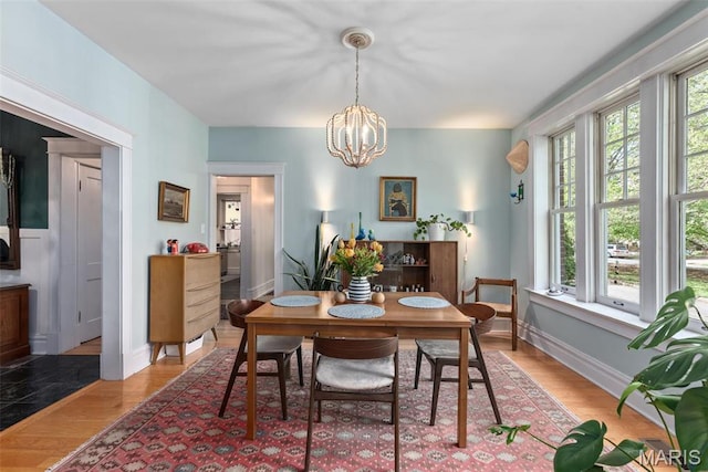 2056 Lafayette Ave Unit 1W, Saint Louis, MO 63104 - dining area with a chandelier, light wood-style floors, and baseboards
