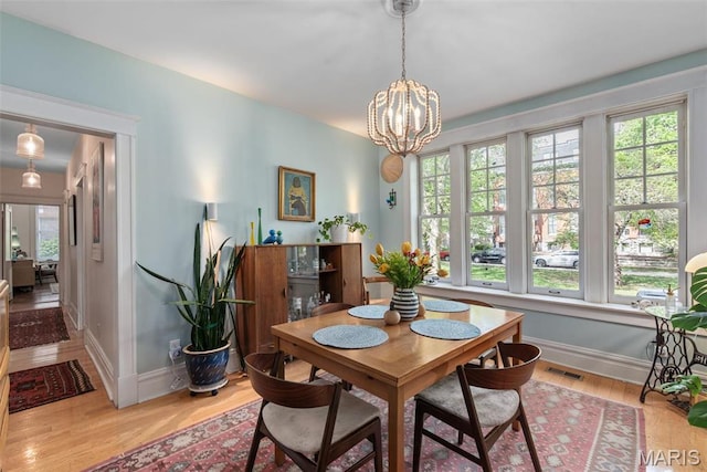 2056 Lafayette Ave Unit 1W, Saint Louis, MO 63104 - dining area featuring baseboards, wood finished floors, and a chandelier