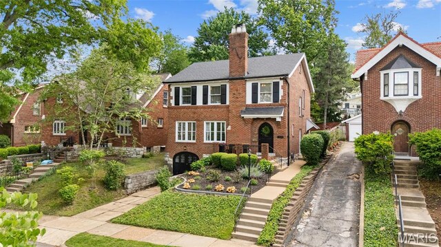 7424 University Dr, University City, MO 63130 - view of front of house with a chimney, brick siding, and stairway