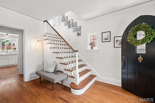 7424 University Dr, University City, MO 63130 - entryway featuring light wood-type flooring, stairs, baseboards, and crown molding