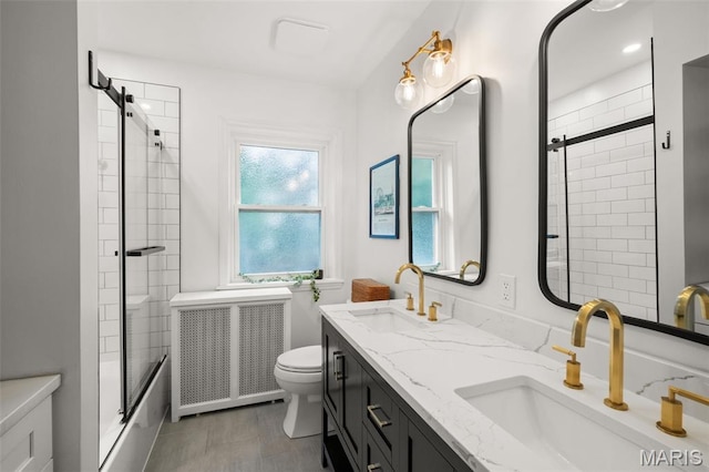 7424 University Dr, University City, MO 63130 - bathroom with radiator, toilet, double vanity, and enclosed tub / shower combo
