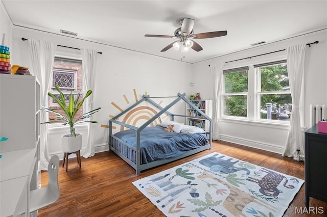7424 University Dr, University City, MO 63130 - bedroom with baseboards, radiator, wood finished floors, and a ceiling fan