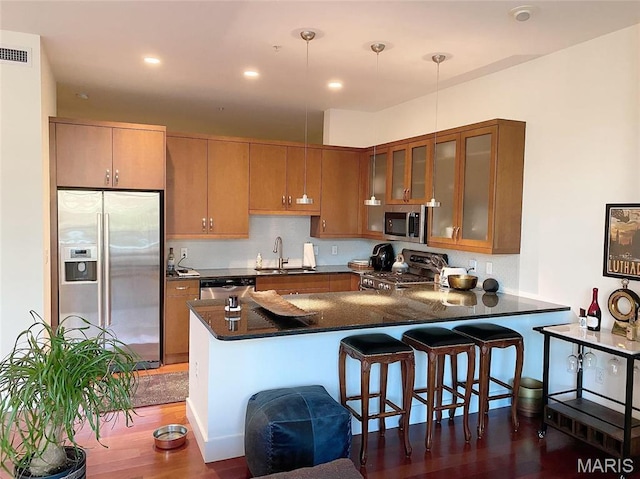 9 N Euclid Ave Unit 510, Saint Louis, MO 63108 - kitchen with stainless steel appliances, a sink, a peninsula, glass insert cabinets, and dark wood-style floors