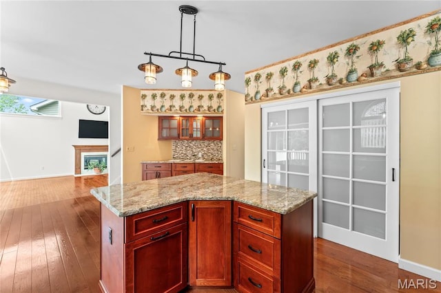 2158 Avalon Ridge Cir, Fenton, MO 63026 - kitchen with backsplash, dark wood finished floors, light stone countertops, decorative light fixtures, and baseboards