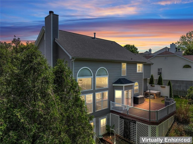 2158 Avalon Ridge Cir, Fenton, MO 63026 - back of house at dusk featuring a deck, a chimney, and a shingled roof