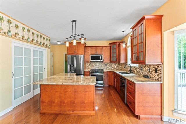 2158 Avalon Ridge Cir, Fenton, MO 63026 - kitchen with appliances with stainless steel finishes, a sink, a kitchen island, backsplash, and light stone countertops