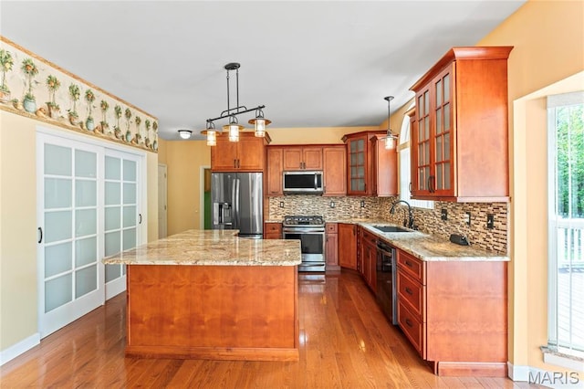 2158 Avalon Ridge Cir, Fenton, MO 63026 - kitchen with appliances with stainless steel finishes, a sink, a kitchen island, backsplash, and light stone countertops