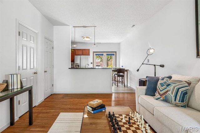3677 Arpent St Unit 3, Saint Charles, MO 63301 - living room with a textured ceiling, wood finished floors, and baseboards