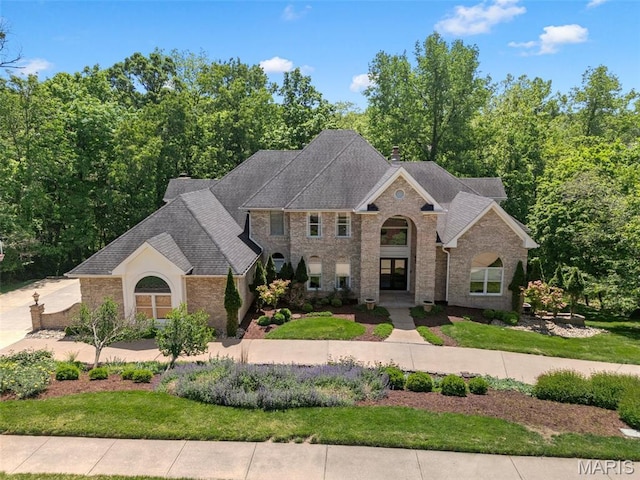 1424 Haarman Oak Dr, Wildwood, MO 63005 - view of front of house featuring a front yard, brick siding, a chimney, and roof with shingles