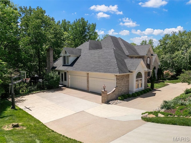 1424 Haarman Oak Dr, Wildwood, MO 63005 - view of side of property featuring concrete driveway, an attached garage, a shingled roof, brick siding, and a chimney
