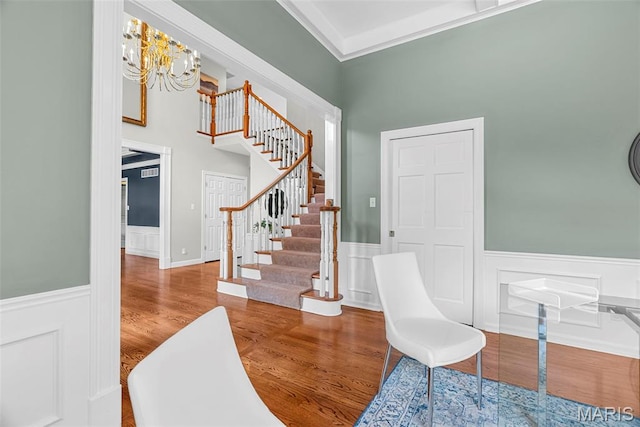 1424 Haarman Oak Dr, Wildwood, MO 63005 - foyer entrance featuring a wainscoted wall, stairway, a chandelier, wood finished floors, and a high ceiling