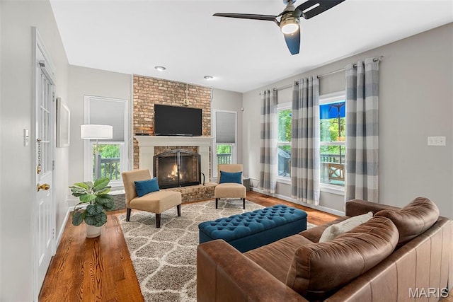 1424 Haarman Oak Dr, Wildwood, MO 63005 - living area featuring wood finished floors, baseboards, ceiling fan, and a brick fireplace