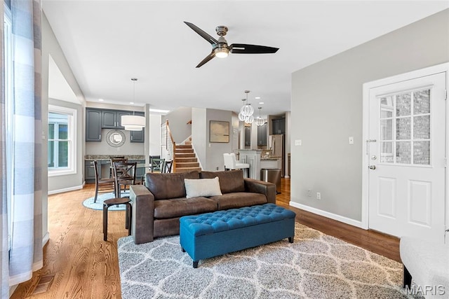 1424 Haarman Oak Dr, Wildwood, MO 63005 - living room with stairway, wood finished floors, ceiling fan, baseboards, and a chandelier