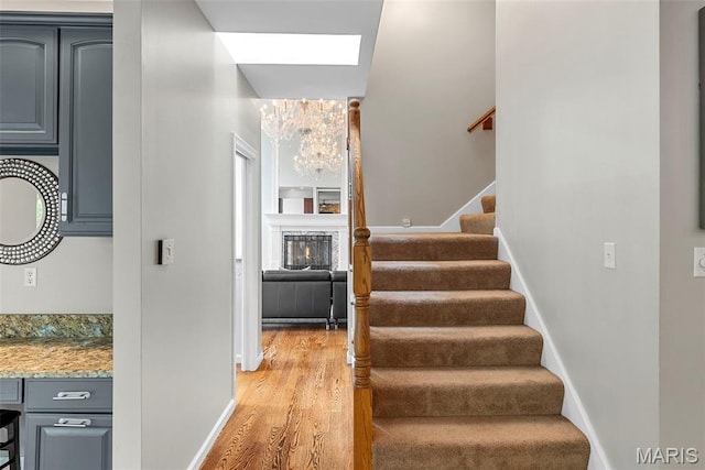 1424 Haarman Oak Dr, Wildwood, MO 63005 - stairs featuring a chandelier, wood finished floors, baseboards, and a skylight