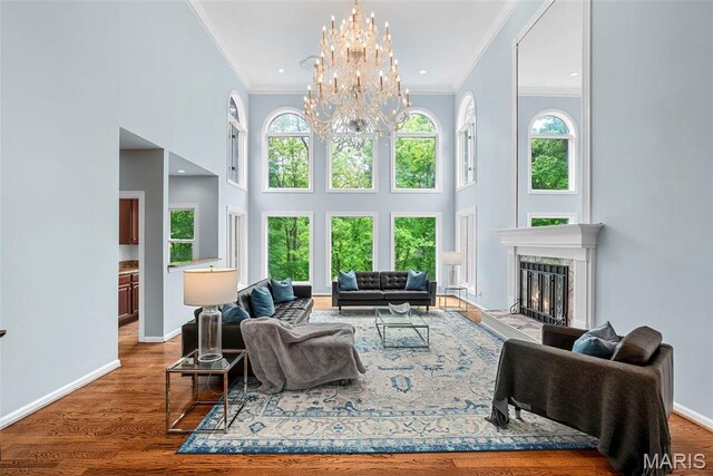 1424 Haarman Oak Dr, Wildwood, MO 63005 - living area featuring crown molding, a high ceiling, a chandelier, a fireplace, and baseboards