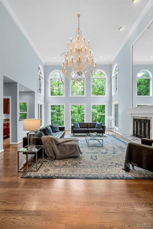 1424 Haarman Oak Dr, Wildwood, MO 63005 - living area with crown molding, a towering ceiling, a premium fireplace, a chandelier, and wood finished floors
