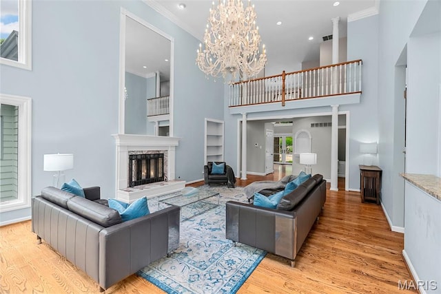 1424 Haarman Oak Dr, Wildwood, MO 63005 - living area with a towering ceiling, crown molding, built in features, a high end fireplace, and light wood-style flooring