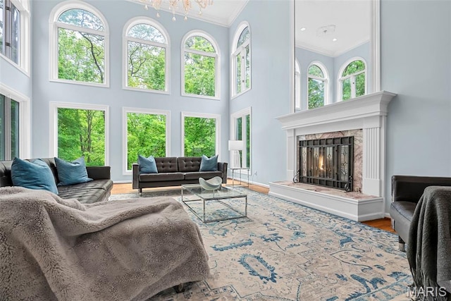 1424 Haarman Oak Dr, Wildwood, MO 63005 - living area with crown molding, a towering ceiling, healthy amount of natural light, a premium fireplace, and a chandelier