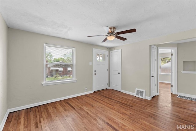 4717 Roxie St, Saint Louis, MO 63121 - foyer entrance with wood finished floors, a ceiling fan, baseboards, and a textured ceiling