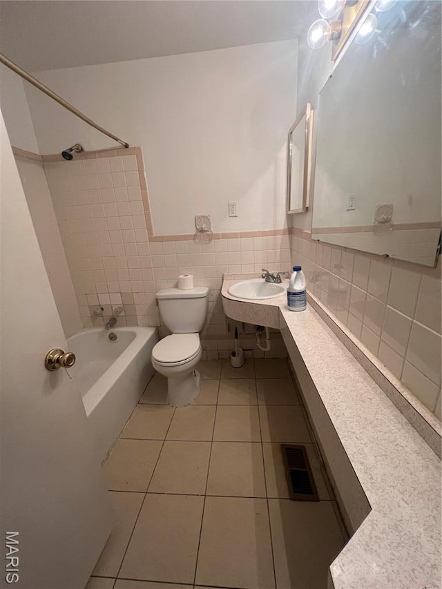 6145 Payne Ave, Saint Louis, MO 63135 - full bathroom featuring shower / washtub combination, toilet, tile patterned flooring, a wainscoted wall, and a sink