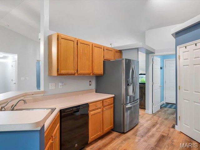 927 Annabrook Park Dr, Ofallon, MO 63366 - kitchen featuring black dishwasher, stainless steel fridge, a sink, light countertops, and light wood-style floors