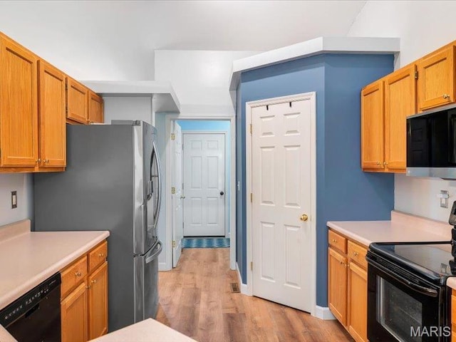 927 Annabrook Park Dr, Ofallon, MO 63366 - kitchen featuring black appliances, light wood finished floors, light countertops, and brown cabinetry