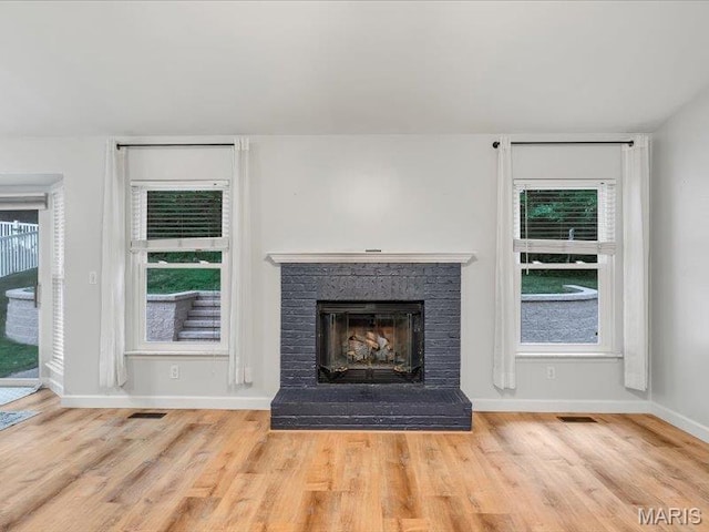 927 Annabrook Park Dr, Ofallon, MO 63366 - detailed view of wood finished floors, a fireplace with raised hearth, and baseboards