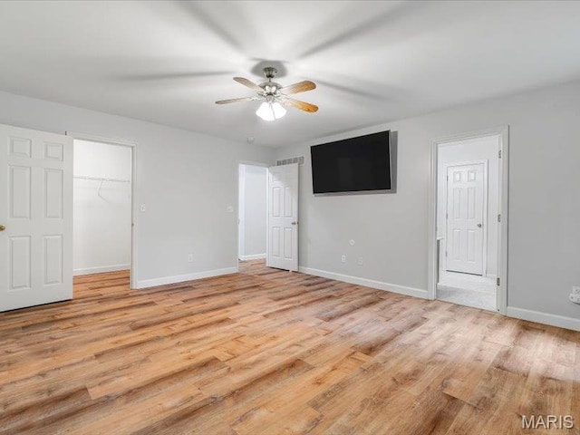 927 Annabrook Park Dr, Ofallon, MO 63366 - unfurnished bedroom featuring baseboards, light wood finished floors, a spacious closet, a ceiling fan, and a closet
