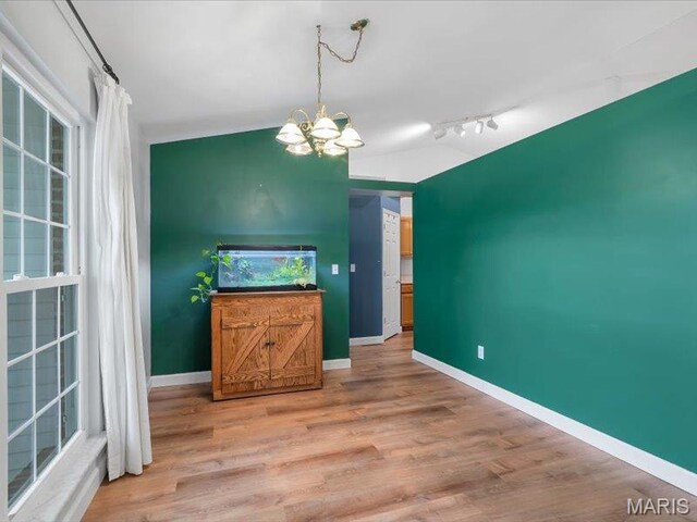 927 Annabrook Park Dr, Ofallon, MO 63366 - unfurnished living room featuring a chandelier, light wood-type flooring, baseboards, lofted ceiling, and track lighting