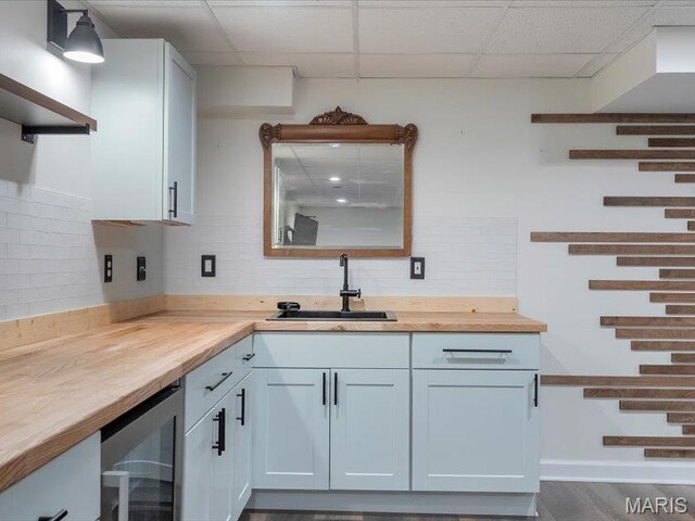 927 Annabrook Park Dr, Ofallon, MO 63366 - kitchen with wood counters, a sink, wine cooler, backsplash, and a paneled ceiling